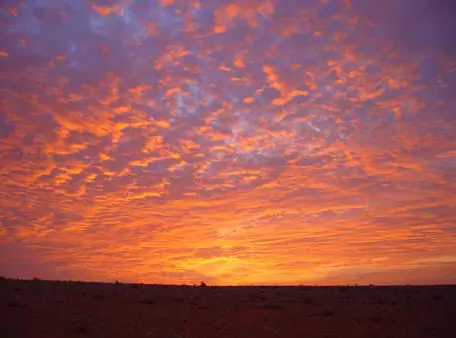 سماء البر وقت الغروب مشتعلة بالأحمر والبرتقالي